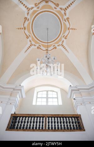 Eine Vertikale einer Kuppeldecke mit einem Kronleuchter in einer Kirche. Stockfoto