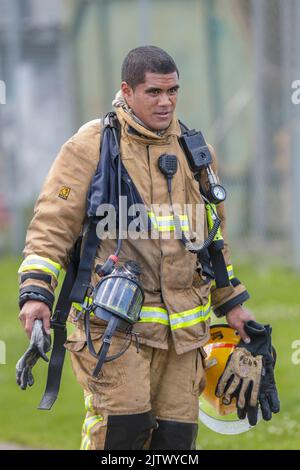 Ein Feuerwehrmann mit Atemgerät, der von einer Feuerszene zurückkehrt Stockfoto