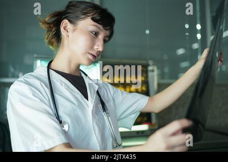 Das Ärzteteam diskutiert die Ergebnisse der Röntgen- oder MRT-Untersuchung des Gehirns des Patienten in der medizinischen Klinik Stockfoto