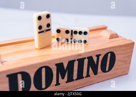 Nahaufnahme von Dominosteinen auf der Spielbox. Zwei Dominosteine auf weißem, isoliertem Hintergrund. Stockfoto