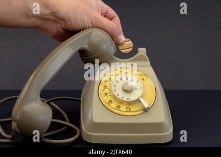 Altes Vintage-Radtelefon und Hand mit Telefonmarke. Stockfoto