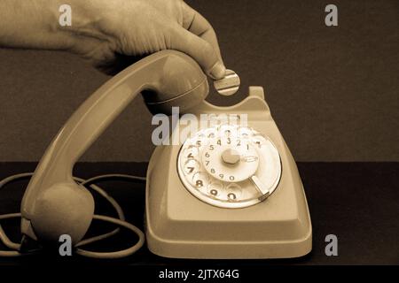 Altes Vintage-Radtelefon und Hand mit Telefonmarke. Stockfoto