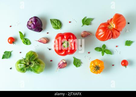 Lebensmittelzusammensetzung. Kreatives Layout aus Bio-Gemüse und Basilikum auf blauem Hintergrund. Draufsicht. Flach liegend. Veganes Lebensmittelkonzept Stockfoto