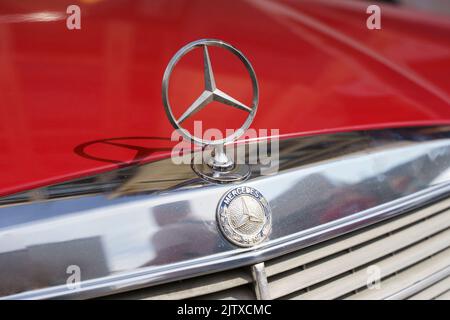 Berlin, Deutschland - 20. August 2022: Retro Mercedes Benz W123 230E und Logo. Altmodisches europäisches Auto. Hochwertige Fotos Stockfoto