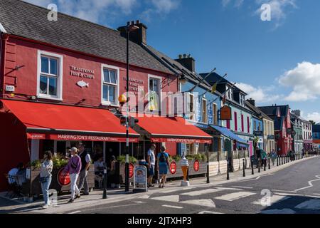 Dingle, Irland - 7. August 2022: Farbenfrohe Häuser an der Hauptstraße des malerischen Dorfes Dingle in der Grafschaft Kerry Stockfoto