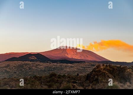 Eine lange Rauchfahne vom Gipfel des Ätna, beleuchtet von der untergehenden Sonne, von der Westseite (Sizilien, Italien) Stockfoto