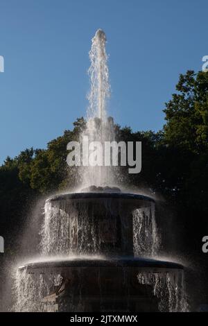 Stufenbrunnen im Park vor dem Hintergrund von Bäumen und dem Himmel. Stockfoto