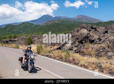 Motorradfahrer fahren die steile Mareneve-Straße auf dem Ätna, Sizilien, Italien hinunter. Die Straße führt vom Skigebiet Piano Provenzana hinunter zur Küste Stockfoto