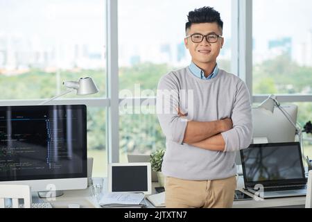 Porträt eines jungen Geschäftsmannes in einer Brille, der im modernen IT-Büro steht Stockfoto