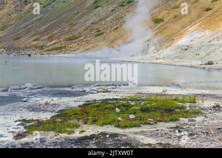 Heißer mineralisierter See mit Thermalquelle und rauchenden Fumarolen in der Caldera des Vulkans Golovnin auf der Insel Kunashir Stockfoto