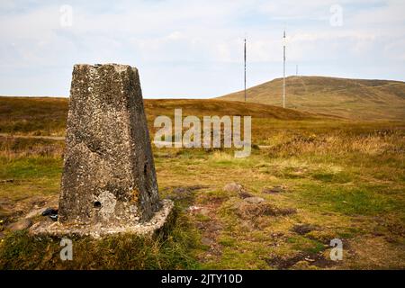 trig Point auf dem Gipfel des schwarzen Berges mit der Sendestation des schwarzen Berges und dem Gipfel des divis Berg im Hintergrund in divis und schwarzem Mo Stockfoto