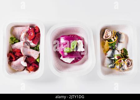 Sammlung von weißen Kunststoff-Take-Away-Boxen mit gesunden Lebensmitteln. Set von Behältern mit täglichen Mahlzeiten - Fleisch, Gemüse und Gesetz Fett Snacks auf weißen BA Stockfoto