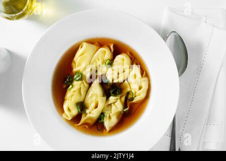 asiatische gedünstete Knödel in Chilischuhe auf einem weißen Tisch serviert Stockfoto