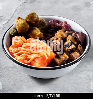 Lachsschüssel (Auberginen, rosenkohlensprossen, karamellisierte Zwiebeln und brauner Reis) Stockfoto