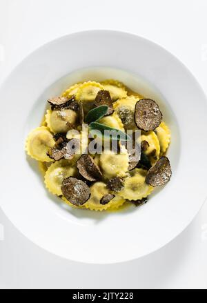 Italienische Ravioli mit Butter, Parmesankäse und Trüffel auf dem weißen Tisch Stockfoto