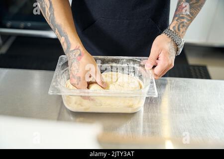 Pizzameister bereitet den gefrorenen Teig zum Bremsen vor Stockfoto