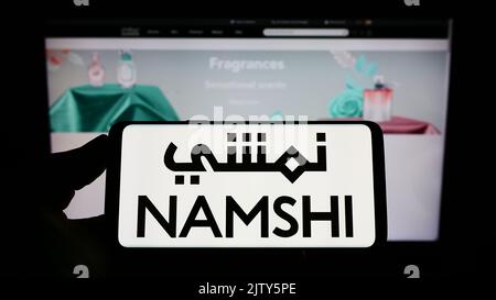 Person, die das Smartphone mit dem Logo des arabischen E-Commerce-Unternehmens Namshi auf dem Bildschirm vor der Website hält. Konzentrieren Sie sich auf die Telefonanzeige. Stockfoto