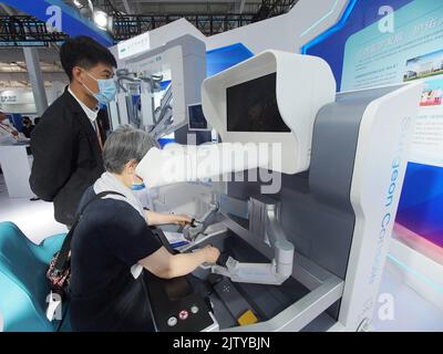 PEKING, CHINA - 2. SEPTEMBER 2022 - Besucher erleben einen endoskopischen Chirurgie-Roboter mit einem Port am Stand des Peking Union Medical College Hospital Stockfoto