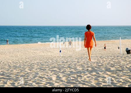 Eine Erwachsene Frau findet an einem sonnigen Sommerferientag Einsamkeit auf dem Sand des Main Beach von East Hampton in den Hamptons Stockfoto