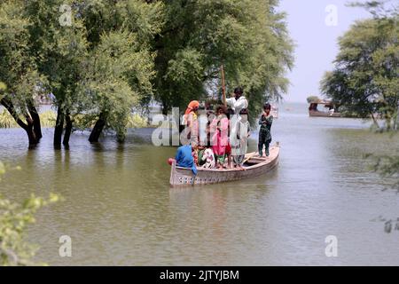 Dadu. 31. August 2022. Am 31. August 2022 fahren von Überschwemmungen betroffene Menschen auf einem Boot im von Überschwemmungen heimgesucht Dadu Distrikt in der pakistanischen Provinz Sindh. Die Gesamtzahl der Todesopfer in Pakistan durch die Monsunregen dieser Saison seit Mitte Juni ist auf rund 1.186 gestiegen, zusammen mit 4.896 Verletzten, nach den Statistiken, die von der NDMA veröffentlicht wurden, nachdem die zuvor veröffentlichten Zahlen überarbeitet wurden. Quelle: Str/Xinhua/Alamy Live News Stockfoto