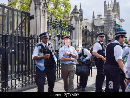 London, Großbritannien. 2.. September 2022. Ein Protestler ruft „Extinction Rebellion!“ Er wird in Handschellen weggeführt, nachdem er sich mit einem Schloss am Zaun vor dem Parlament befestigt hat. Die Demonstranten der Extinction Rebellion klebten sich im Parlament ein, während andere sich nach draußen sperrten und festklebten und eine Bürgerversammlung forderten. Kredit: Vuk Valcic/Alamy Live Nachrichten Stockfoto