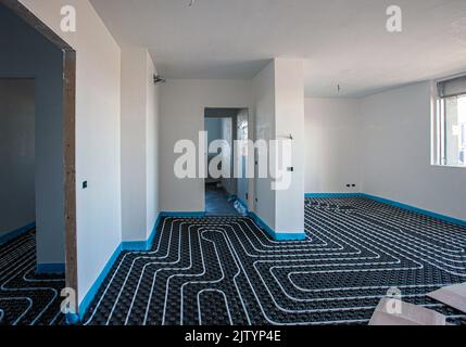 Fußbodenheizung. Fußbodenheizung in einem modernen Gebäude im Bau. Stockfoto