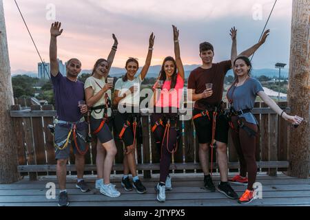 Eine Gruppe von Kletterern, die ein Foto machen und mit dem Sonnenuntergang im Hintergrund lachen Stockfoto