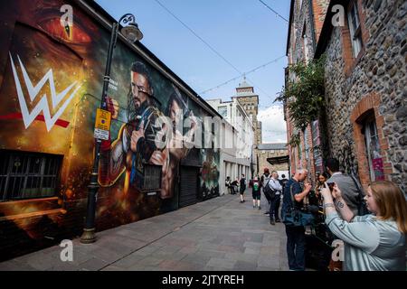 Cardiff, Wales, Großbritannien. 2. September 2022. Fotos werden vor einem Wandbild von Wrestlern gemacht, während die Aufregung für den WWE Clash beim Castle Wrestling Event im Fürstentum Stadium am 3. September wächst. Kredit: Mark Hawkins/Alamy Live Nachrichten Stockfoto