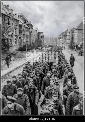 WW2 Nazi-deutsche Gefangene Oktober 1944 "die endlose Prozession der deutschen Gefangenen, die mit dem Sturz des Nazi-Deutschlands Aachen gefangen genommen wurden, marschiert durch die zerstörten Straßen der Stadt in die Gefangenschaft.als Kriegsgefangene", bewacht von Mitarbeitern der amerikanischen Armee Stockfoto