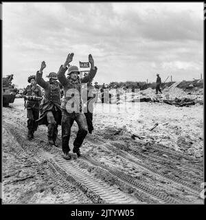 WW2 D-Day - von britischen Streitkräften während der Invasion der Normandie gefangene deutsche Nazi-Kriegsgefangene 6. Juni 1944 die Wehrmacht war von 1935 bis 1945 die vereinte Wehrmacht Nazi-Deutschlands. Deutsche Kriegsgefangene mit hochhändiges Geleit an einem der Strände der Goldregion, 6. Juni 1944. Normandie Frankreich Stockfoto