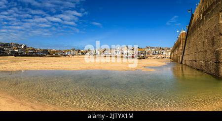 St. Ives Hafen. Leuchtturm, Fischerboote und kornische Ferienhäuser. Stockfoto