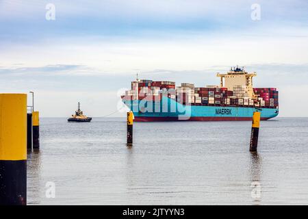 Schlepper führt das Containerschiff Maersk Luz zum Entladebereich im Überseehafen Bremerhaven Stockfoto