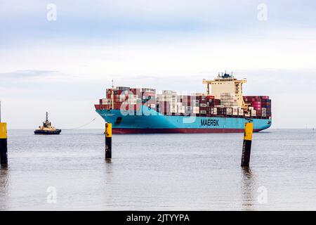 Schlepper führt das Containerschiff Maersk Luz zum Entladebereich im Überseehafen Bremerhaven Stockfoto