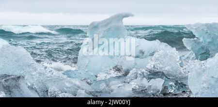 Eisbrocken brachen vom Gletscher ab, schweben ins Meer und waschen sich dann auf dem schwarzen Sand des Diamond Beach in Jökulsárlón, der Südküste Islands. Stockfoto