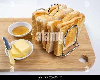 Frühstück Toast im Regal mit Butter und Marmelade weißen Hintergrund Stockfoto