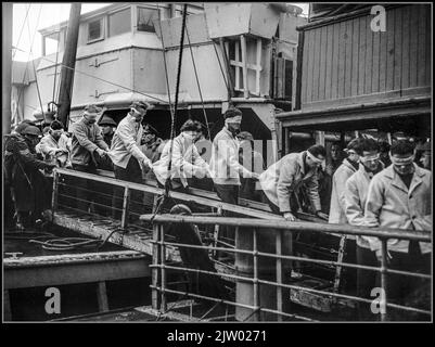 NAZI-Kriegsgefangene WW2 Scharnhorst Schlachtschiff sinkende Nazi-Kreigsmarine-Matrosen Kriegsgefangene Überlebende bei Scapa Flow, 2. Januar 1944 mit verbundenen Augen DIE SCHARNHORST-Überlebenden, in einem Seemannsrettungskoffer, mit verbundenen SicherheitsAugen, gingen von der SS St. Ninian auf dem Weg zur Kriegsgefangenenstation über eine Bandenleiste. Datum 2. Januar 1944 Stockfoto