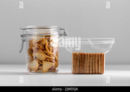 Gesalzene Kekse oder Cracker im Glas und in einer Plastiktüte Stockfoto