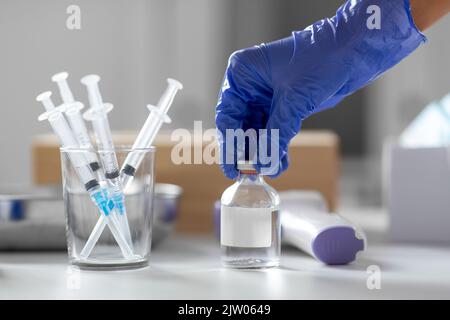 Spritzen und Hand in Handschuh öffnen Medizin Stockfoto