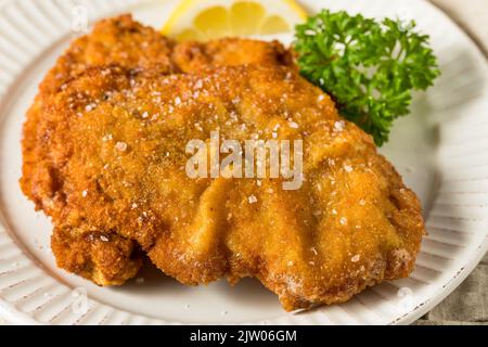 Hausgemachtes, tiefgebratene deutsche Schweineschnitzel mit Salz und Zitrone Stockfoto