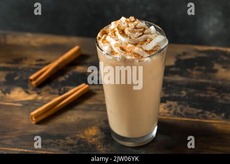 Hausgemachter, gewürzter Latte mit Iced Pumpkin und Schlagsahne Stockfoto