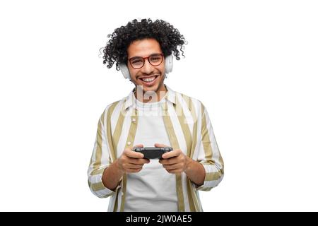 Lächelnder Mann mit Gamepad, der Videospiel spielt Stockfoto