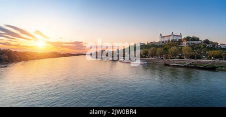 Panoramablick auf die Donau und die Burg von Bratislava bei Sonnenuntergang - Bratislava, Slowakei Stockfoto