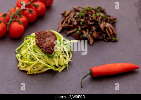 Zucchini-Spaghetti mit getrockneten und getrockneten Tomaten Stockfoto