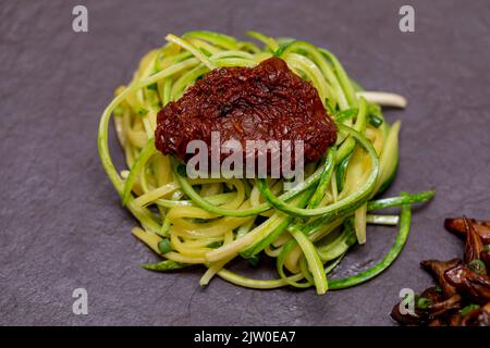 Zucchini-Spaghetti mit getrockneten und getrockneten Tomaten Stockfoto