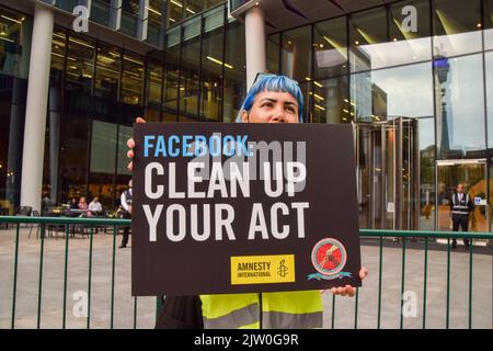 London, England, Großbritannien. 2. September 2022. Ein Protestler hält ein Plakat mit dem Aufsteller „Facebook bereinigen Sie Ihre Handlung“. Demonstranten, darunter Mitglieder von Amnesty UK, versammelten sich vor den Büros von Meta (ehemals Facebook) in London in Solidarität mit Guillermo Camacho, einem saubereren und Gewerkschaftsführer, der 2021 von einem der Vertragspartner von Meta entlassen wurde, nachdem er einen Protest gegen das Unternehmen wegen der Arbeitsbedingungen veranstaltet hatte. Amnesty hat Meta vorgeworfen, die Arbeitnehmerrechte verletzt zu haben. (Bild: © Vuk Valcic/ZUMA Press Wire) Bild: ZUMA Press, Inc./Alamy Live News Stockfoto