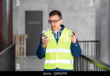 Männlicher Architekt, der im Büro ein Smartphone anruft Stockfoto