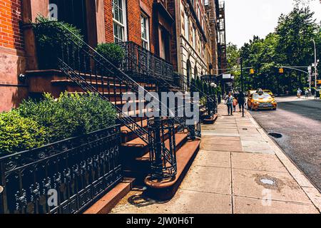 Menschen, die auf einem Bürgersteig in New York City entlang des gelben Taxis gehen, New York City, New York State Stockfoto