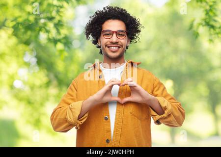 Fröhliche Herzensgeste auf natürlichem Hintergrund Stockfoto