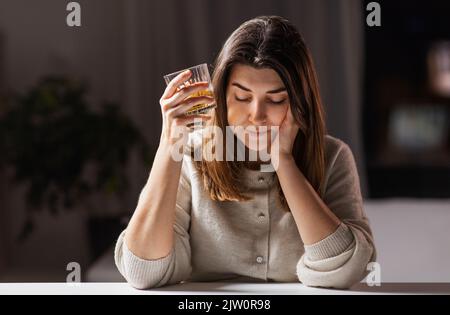 Alkoholikerin, die zu Hause starken Alkohol trinkt Stockfoto