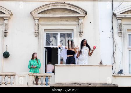 Notting Hill Carnival 2022 kehrt nach 3 Jahren aufgrund der Pandemie nach London zurück. Im Bild: Nachtschwärmer feiern das Fest auf einem Balkon. Bild sho Stockfoto